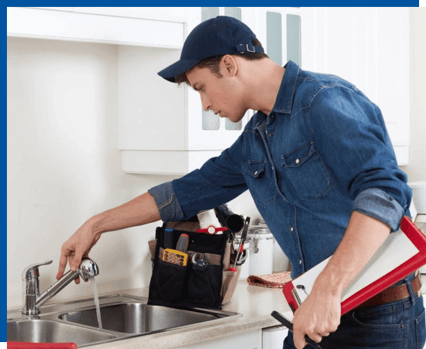 A man is working on the kitchen sink.