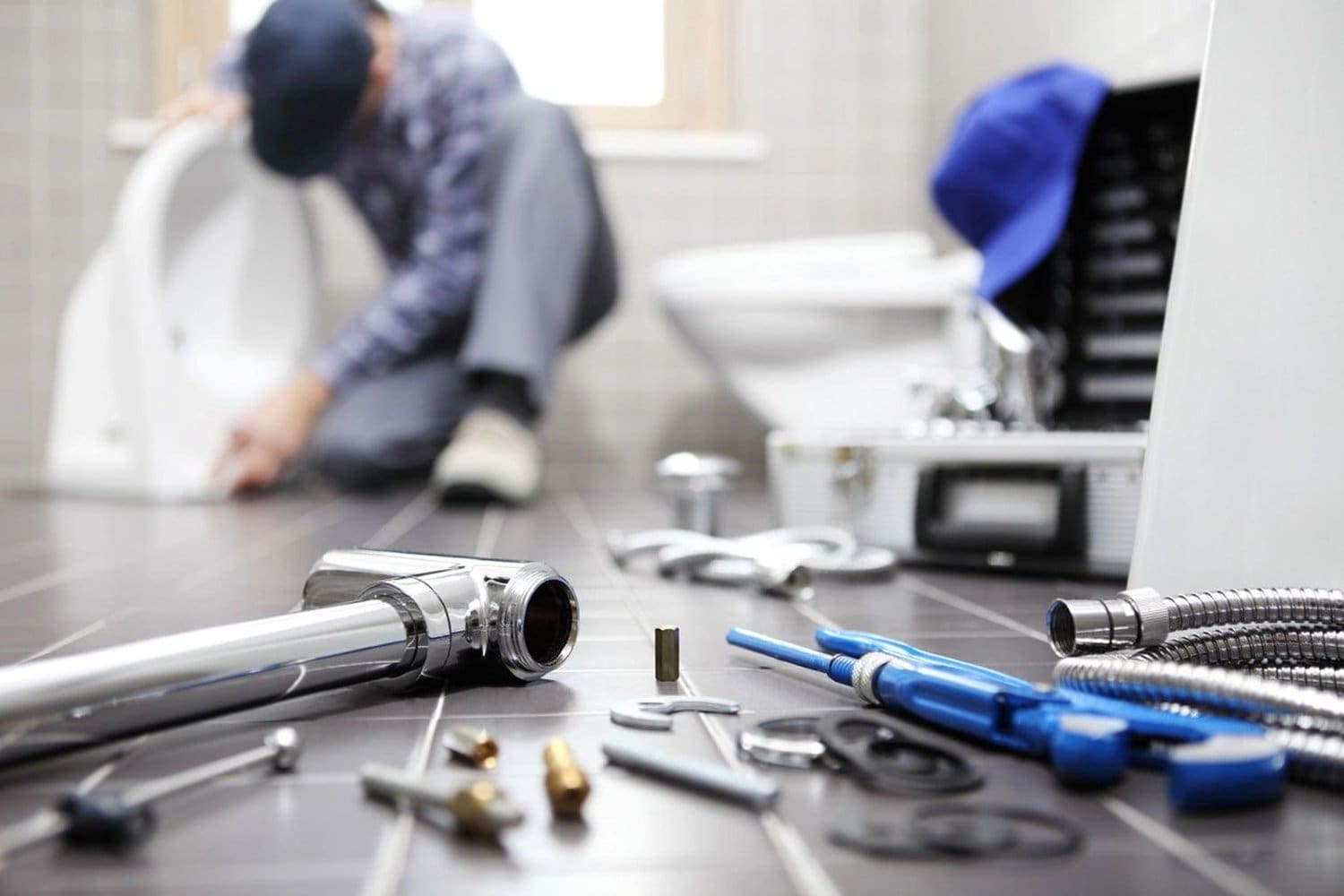 A man sitting on the floor with some tools