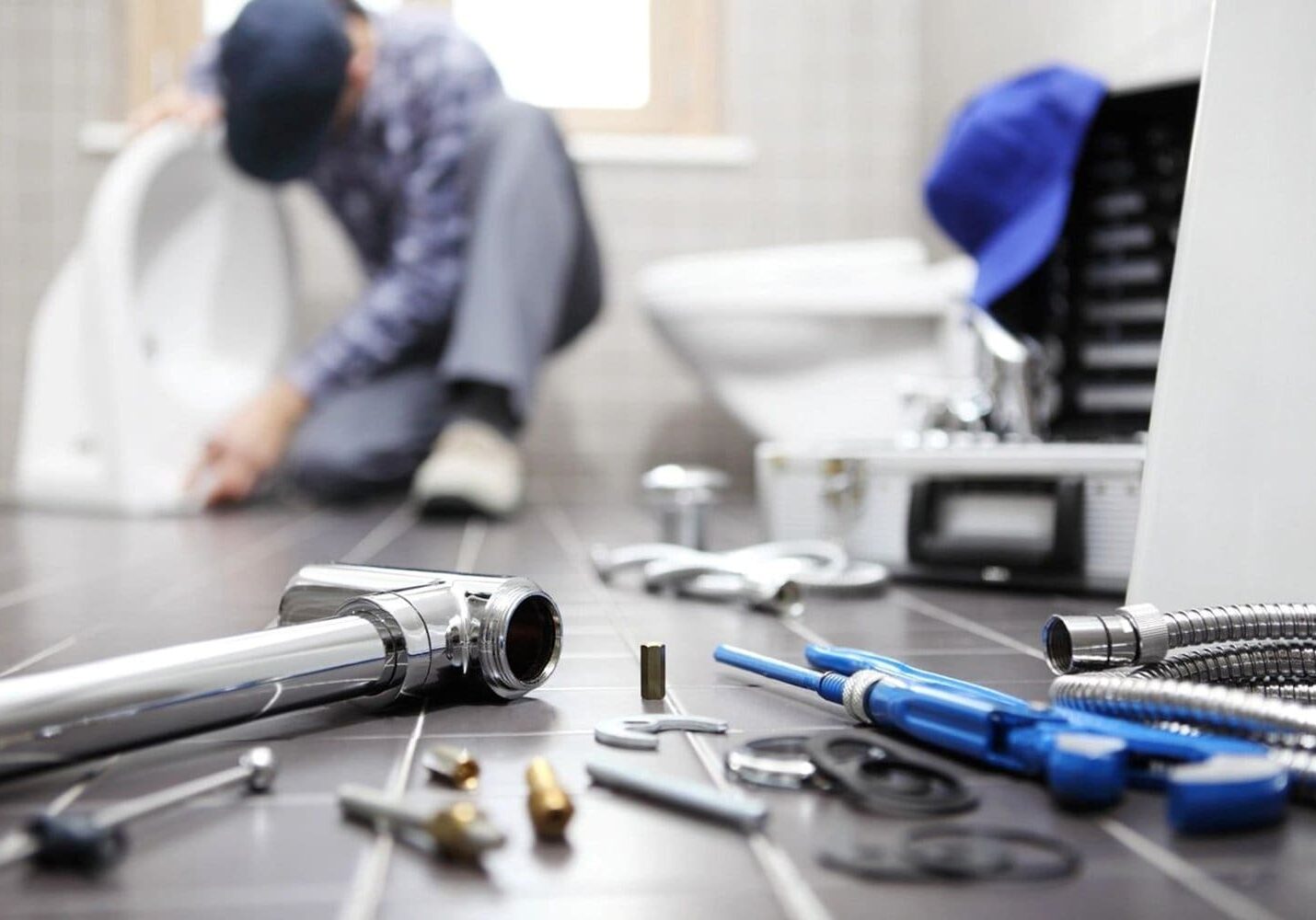 A man sitting on the floor with some tools